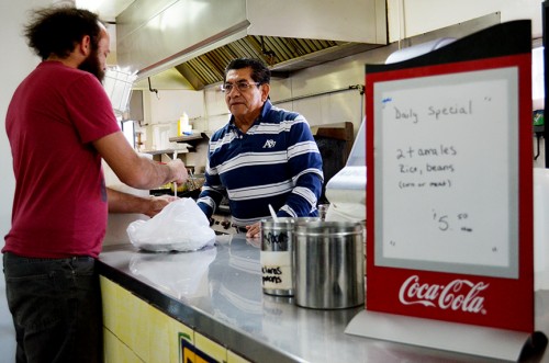 Don Nacho serves a customer at his restaurant, Taqueria Pico de Gallo, during lunch time.
