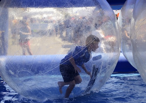 Kyle Vance, 8, runs in ball on top of water at the Feria de Sur Tucson on Sunday, April 6, 2014. The attraction at the fair was called Laguna Bubbles and it is similar to bumper cars. (Photographyby Ryan Revock)