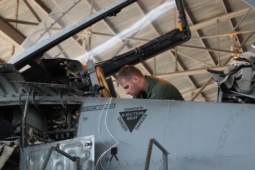 Eric Breen, former Air Force, works to install the Helmet Mounted Queuing System in an A-10 on the Desert Speed Line. Photo by: Jade Nunes