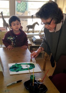 Studio art teacher Mimi Gray helps a student with his self-portrait. (Photograph by Hollie Dowdle)
