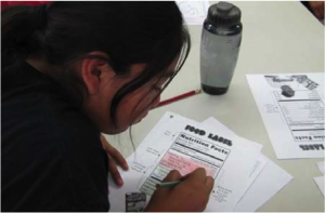 Youth learn about nutrition food labels at the American Indian Youth Wellness Camp. Photo Courtesy: Native American Research and Training Center