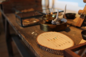 Locally made jewelry displayed on pieces of wood. (photo by Amy Johnson) 