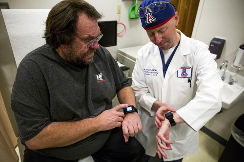 David G. Armstrong (right), professor of surgery and College of Medicine director at the University of Arizona, discusses with his patient Andreas Proroczok (left) how a mobile health device called SurroSense Rx helped with Proroczok's Neuropathy and pressure points within in his feet at Banner- University Medical Center Tucson on Monday, Feb. 23, 2015. Photo by: Rebecca Marie Sasnett / Arizona Sonora News Service