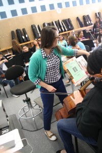 Margie Looney helping students tune their instruments one by one before class begins. March 23, 2015. Photograph by Alexandra Adamson 