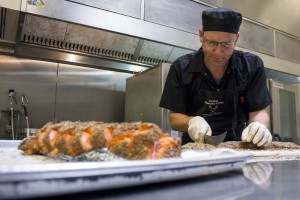 David Rogers, student cook, cuts salmon for the graduation dinner at Caridad Community Kitchen, 845 N. Main Ave, on Friday, May 1, 2015. Students made dishes to match the Hawaiian theme of the graduation ceremony. Photo taken on Friday, May 1, 2015. Photo by Rebecca Marie Sasnett / Arizona Sonora News 