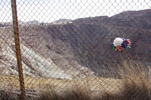 A bouquet sits in the fence above the mine at a viewing area.