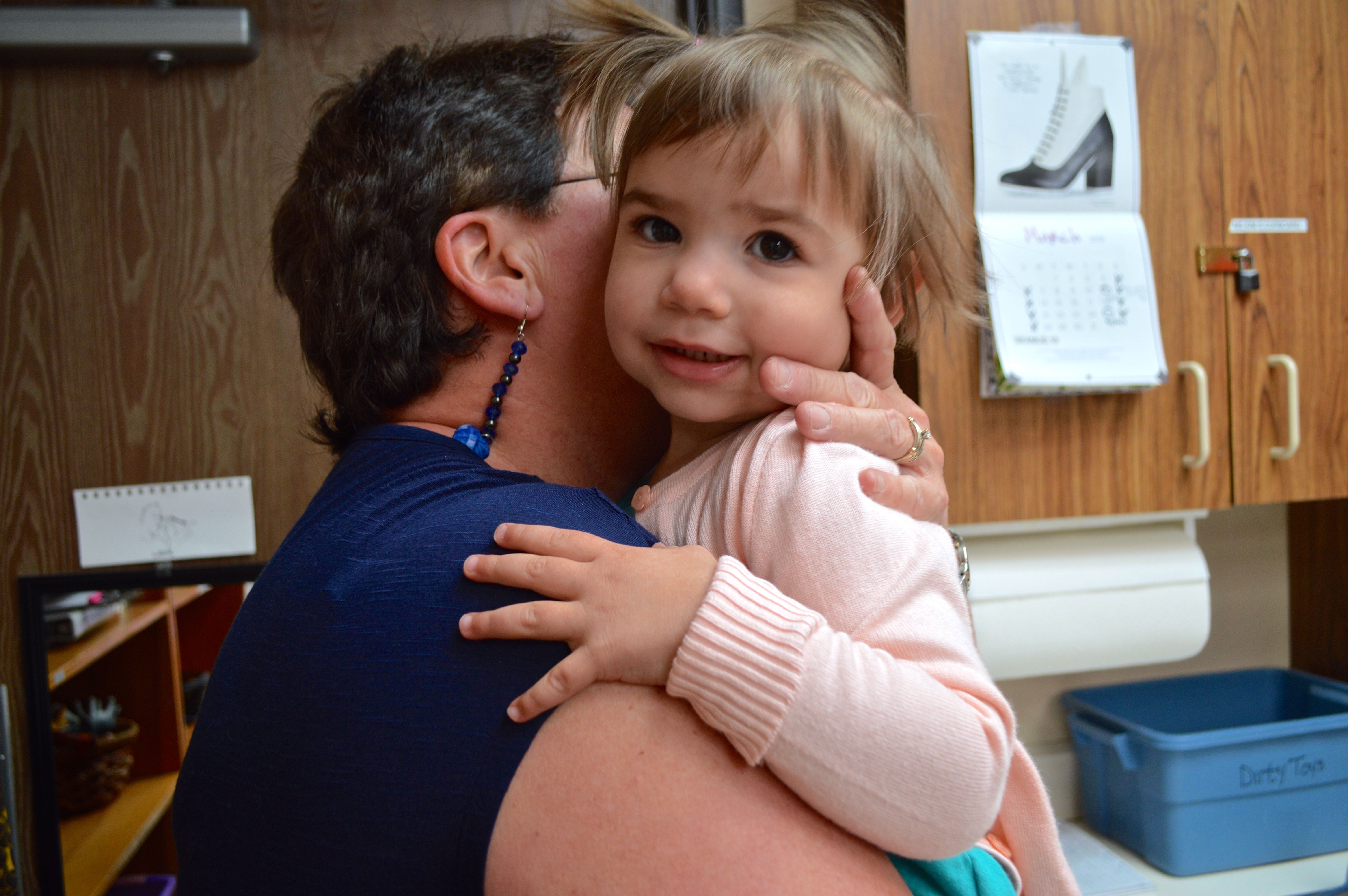 A caretaker hugs Paloma after putting on her shoes. Photo by Shannon Higgins/Arizona Sonora News