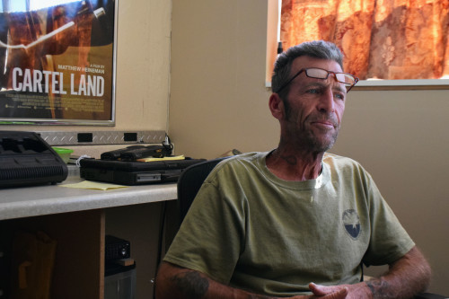 Foley, in his office at the Arizona Border Recon headquarters, sits in front of a poster from the documentary Cartel Land, which featured Foleys vigilante justice.