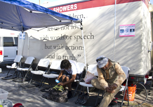 People taking off their shoes and preparing to use the shower shuttle. (Photo by: Jordan Glenn/El Independiente)