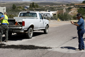 Carrafa takes pictures on his camera phone at a pothole being filled - possibly as future fodder for an article in the Tombstone Gazette. (Photograph by Devon Confrey / Arizona Sonora News)