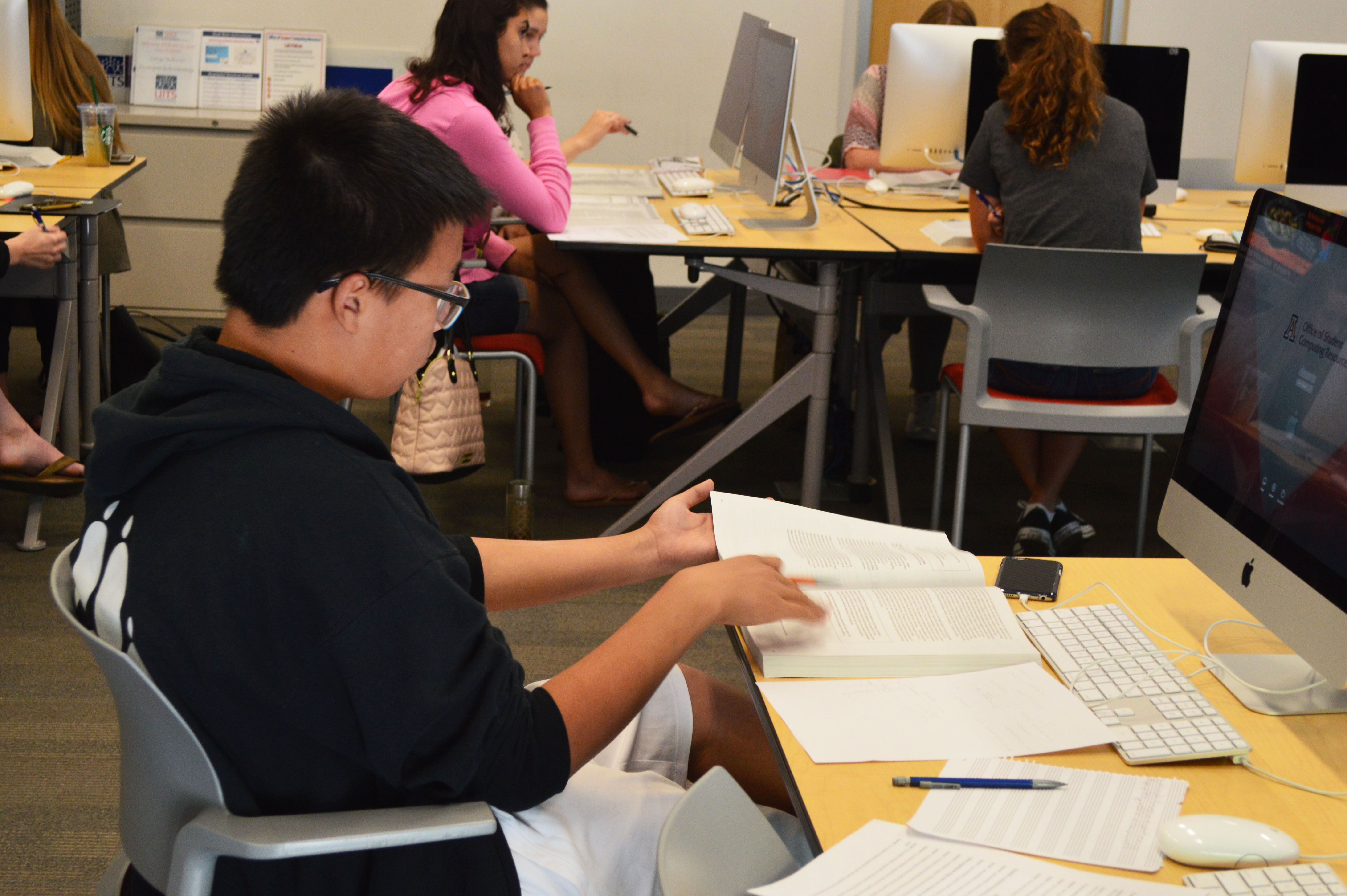 A student flips through an SAT prep book at UA's Think Tank tutoring session. Photo by Shannon Higgins/Arizona Sonora News