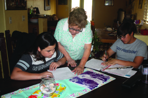 Laura Jasso, en el medio, ayuda sus nietas Elysia Jasso, a la izquierda, y Eliana Jasso, a la derecha, con sus tareas. 