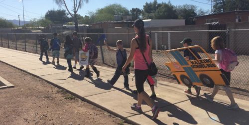 The adult leader leads the kids on a walk to school. Photo by Safe Routes Tucson