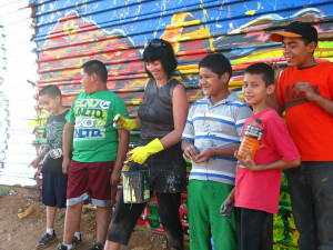 Baer and children painting the Mexico/ United States wall for the Border Bedazzlers project.