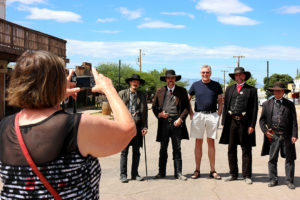 A German tourist takes a picture of her husband while he poses with the O.K. Corral reenactors on Allen Street in Tombstone, Ariz. on Sunday, Sept. 25, 2016. The actors were advertising for the 12 o'clock reenactment of the infamous shootout between Virgil Earp, Morgan Earp, Wyatt Earp and Doc Holliday against the McLaurys and the Clantons that took place on Wednesday, Oct. 26, 1881. (Photo by Julianne Stanford / Arizona Sonora News Service)