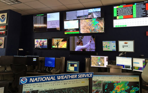 A collage of illuminated screens line the wall of the NWS office on Sept. 13, 2016. These screens were busy showing active thunderstorms as meteorologists closely monitored. (Photograph by Taylor Dayton / Arizona Sonora News Service)