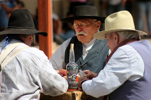 Members of the Tombstone Vigilantes reenactment group play a hand of cards during a reenactment on Allen Street in Tombstone, Ariz. on Sunday, Sept. 25, 2016. The groups performs every second, fourth and fifth Sunday each month. (Photo by Julianne Stanford / Arizona Sonora News Service)