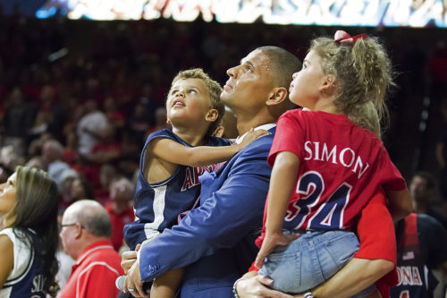 Miles Simon and his children watch the video of the introduction his jersey retirement in McKale Center in Tucson on Oct. 14, 2016.  (Photo by Emily Gauci / Arizona Athletics)