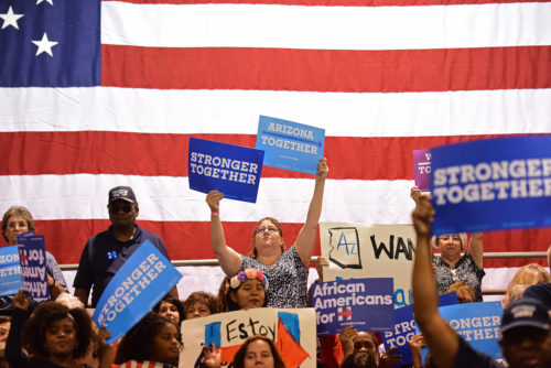 A Clinton support holds up signs before First Lady Michelle Obama's speech at the Phoenix Convention Center in Phoenix, Ariz. on Thursday, Oct. 20, 2016. (Photo by Rebecca Noble / Arizona Sonora News)