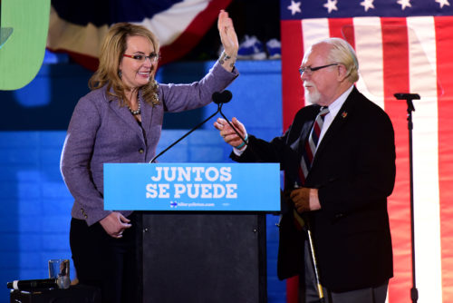 Rep. Gabrielle Giffords waves hello to the audience accompanied by Rep. Ron Barber before a speech from Democratic vice presidential candidate Tim Kaine at Sunnyside High School in Tucson, Ariz. on Thursday, Nov. 3, 2016. (Photo by Rebecca Noble / Arizona Sonora News)