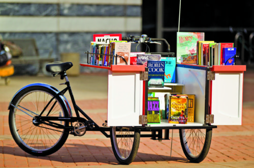 Photo of Pima County's first Book Bike on January 30, 2012 at the Joel D. Valdez Main Library. The modified cargo bike, made by Haley Tricycles in Philadelphia, is outfitted with book shelves. Donated books will be given away during appearances. (Photo courtesy of Pima County)