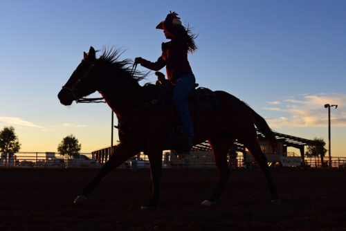 Tabytha Friend holds onto her hat in high winds while circling at the Wentz Point Arena in Marana, Ariz. on Wednesday, Nov. 30, 2016. (Photo by Rebecca Noble / Arizona Sonora News)