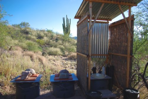 David and Pearl Omicks barrel composting toilet system in Cascabel, Arizona in October, 2016. The two barrels on the left are composting, and the barrel in the outhouse is in use. Because the outhouse faces the remote desert, there is no need for a door. (Photo by Michaela Webb / Arizona Sonora News)