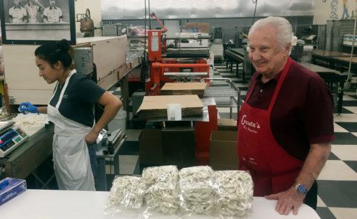 Jim Cerreta Sr., founder and owner of Cerreta Candy Company smiles while standing next to fresh white chocolate covered pretzels. (Photo by Amanda Lennon/Arizona Sonora News Service)