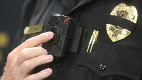 Police officer turning on his body-worn camera.