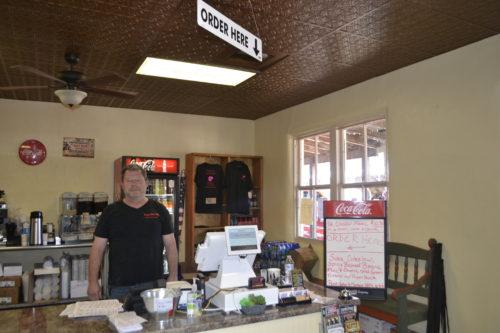 John Marshall, the owner of Puny Johns Restaurant stands behind the register of his newly opened restaurant. (Photo by: Cassidy Blumenthal) 
