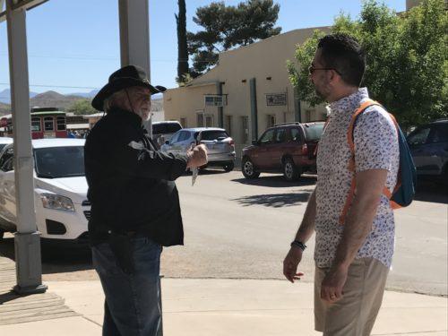 Cowboy Chris talks to a tourist walking by. (Photo by: Justin Spears/Arizona Sonora News)