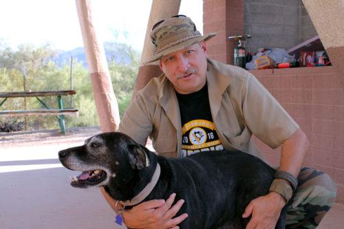 Harry Hughes poses for a portrait with his dog, Bailey, in a trailer park ramada near Maricopa, Ariz. Hughes is retired and spends his time advancing the cause of the National Socialist Movement in the United States. Photo by: Erik Kolsrud/Arizona Sonora News