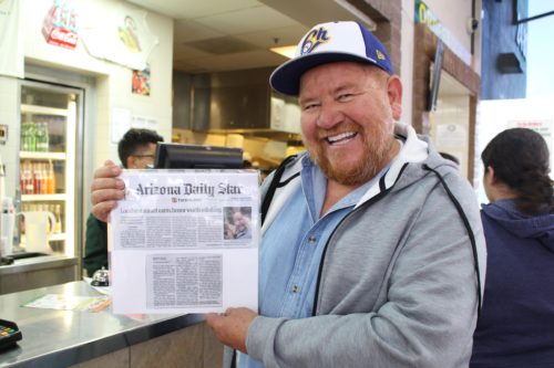 Owner Daniel Contreras poses with a clipping from the Arizona Daily Star announcing the James Beard Award.