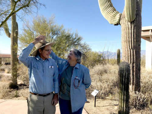 Tom Orum, right, and Nancy Ferguson, left, stand under a tree near the Visitor Center at Saguaro National Park in Tucson, Ariz. (Photo by: Ava Garcia / Arizona Sonora News)