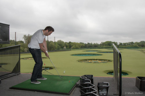 Male Millennial hits a golfball in England at Topgolf’s first facility. (Photo by Mark Walker)