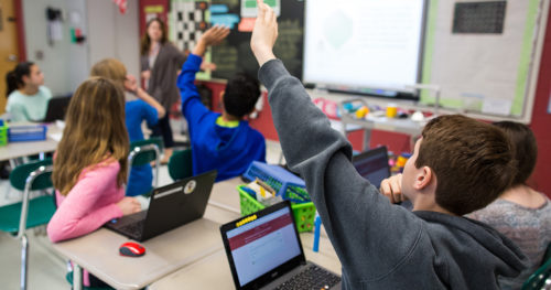 Students raising hands in classroom. (Photo by: Google for Education)