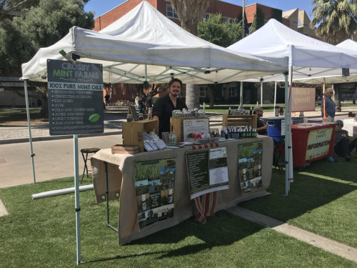 Tyler Crosby of Crosby Mint Farm stands at the farms booth at a farmers market on the University of Arizona campus Wednesday, April 25. Crosbys family has operated a mint farm in Tucson for 10 years. (Photo by Ava Garcia/Arizona Sonora News Service)