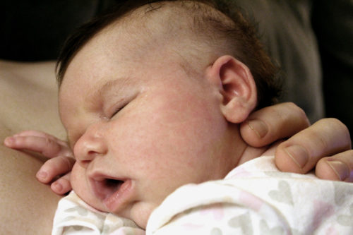Irene Sundell, three months old, sleeps on her fathers chest.