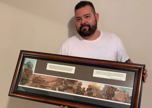 Beto Ureña depicted here 16 years after the invasion of Baghdad holding a plaque remake of the famous photograph of him during the war that was given to him by his unit, 3/7, after the end of his enlistment in the Marines. (Photo by Alberto Quiroz).