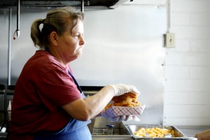 Frances Montano, one of Sues' employees, serves up an order of their famous fish and chips during the restaurant's busy lunch hour. (Photographed by Ashley Powell)