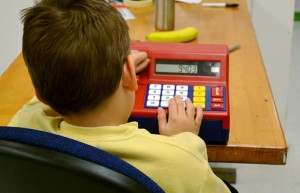 One of Wing's students with autism plays with a toy register. Intermountain Centers for Human Development emphasizes the importance of math skills by rewarding students "bear bucks," which they can use to buy prizes.