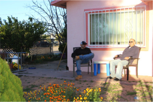 J.J. Hernández y su padre sentados en frente de su casa, ubicada en el sur de Tucson, disfrutando del clima fresco. (Foto por Michaela Kane/ Arizona Sonora News)