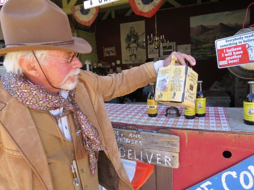 Fields holds up a custom sarsaparilla bottle holder. (Photo by: Kaleigh Shufeldt / Arizona Sonora News) 