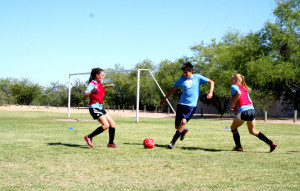 Players move to the ball during a co-ed scrimmage at a skills clinic on April 25, 2015 in Tucson, Arizona. The field during scrimmages is coned off to be smaller than normal, requiring more skill from the players. (Photo: Cam Chery / Arizona Sonora News)
