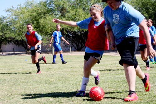 Kristen Richards and Chris Wallace battle for the ball at a co-ed skills clinic on April, 25, 2015 in Tucson, Arizona. Drills are organized for players to work on footwork and ball skills. (Photo: Cam Chery / Arizona Sonora News)