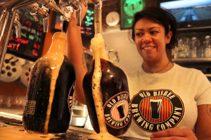 Bartender happily fills up two growlers for customers to take home. Photo by Emily Lai/Arizona Sonora News Service.