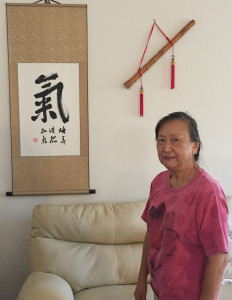 Chia-Lin Pao Tao poses next to a scroll she made symbolizing vital energy (Photo by: Zachary Pleeter/Arizona Sonora News).