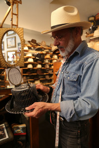 S. Grant Sergot gets ready to take a head measurement with a conformer, an antique device that maps out a hat customer's head shape. (Full disclosure: The writer's head is potato shaped, according to Sergot.) Photo by Karen Schaffner/Arizona Sonora News Service