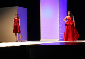 Student models at Flowing Wells High School prepare to walk down the runway at the school's 2016 Fusion fashion show. Multiple students created their own version of a red dress that was featured in a design competition at the Southern Arizona AIDS Foundation's Moda Provocateur fashion show earlier that year. (Photo by Maggie Driver)