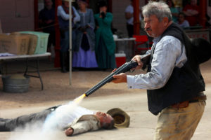 Frank Cara of the Tombstone Vigilantes fires a prop rifle during a reenactment in Tombstone, Ariz. on Sunday, Sept. 27, 2016. (Photo by Julianne Stanford / Arizona Sonora News Service)